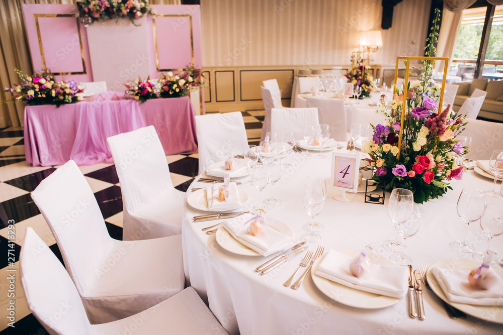 Round white table with elegant compositions from natural flowers. Banquet at the luxury wedding. Elegant design wedding table. Round white table with elegant compositions from natural flowers. Banquet at the luxury wedding. Elegant design wedding table.
