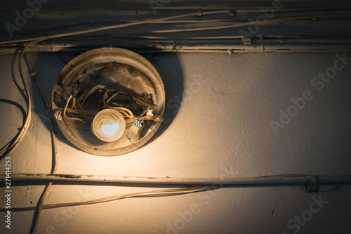 An old light bulb with a bad wiring on the wall