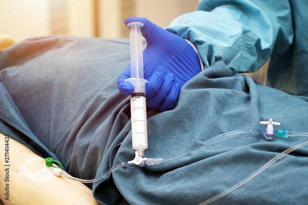 Doctor injects the patient intravenously with the drug propofol via