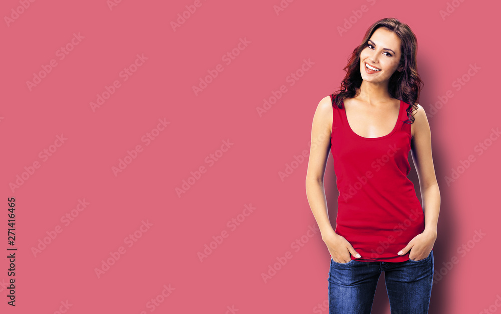 Portrait photo of young smiling woman in casual clothing, blue jeans. Red color background. Copy space. Portrait photo of young smiling woman in casual clothing, blue jeans. Red color background. Copy space.