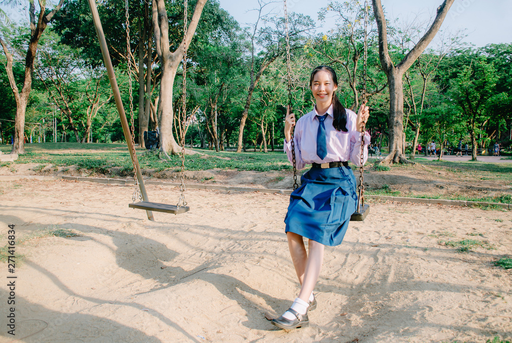 Portrait of asian girl student in school uniform Thailand style, sitting on swing and enjoy herself in windy and sunny day. Portrait of asian girl student in school uniform Thailand style, sitting on swing and enjoy herself in windy and sunny day.