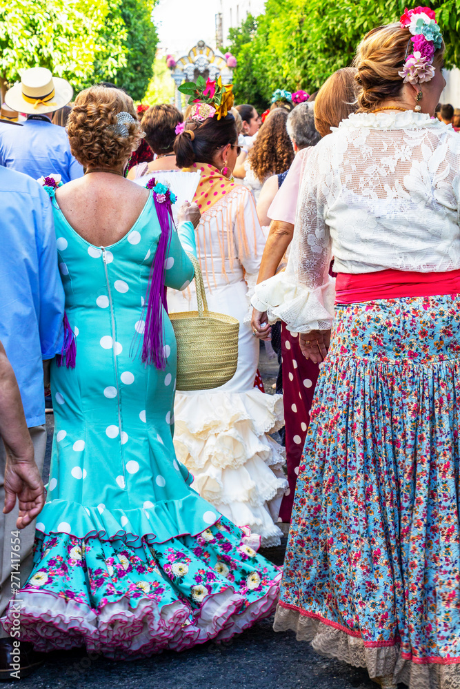 Rear view of beautiful dressed female participants at the procession of Feria de Cordoba, Feria de Nuestra Senora de la Salud or Cordoba Fair