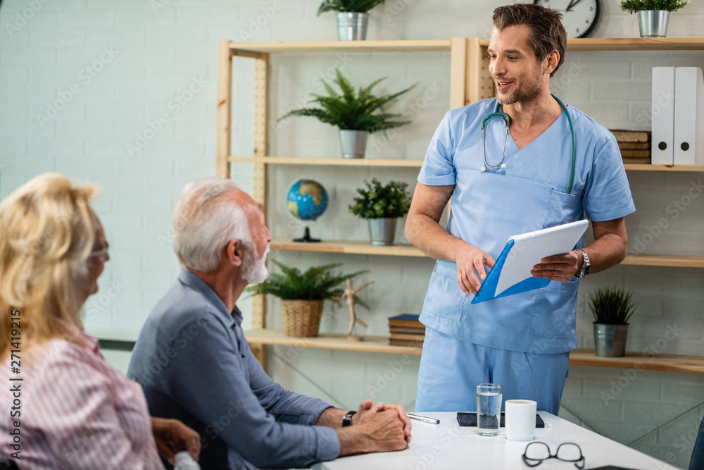 Happy doctor talking with a senior couple at his office. Happy doctor talking with a senior couple at his office.