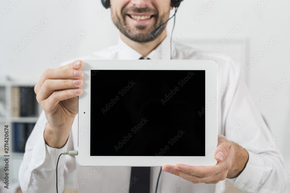 Man in call center showing tablet Man in call center showing tablet