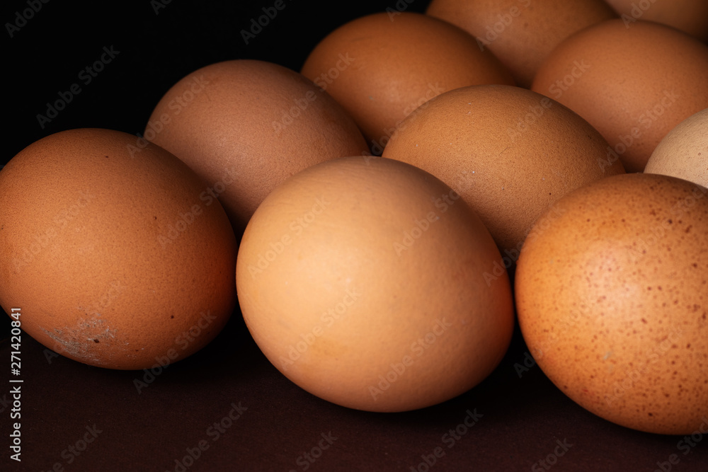 Brown chicken eggs in a row on a two-color background.