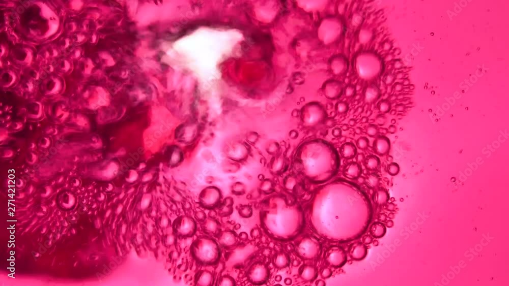 Pink drink is poured into a glass, view from the nirzu, transparent bottom Pink drink is poured into a glass, view from the nirzu, transparent bottom