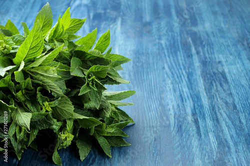 Mint. Leaves and branches of fresh green wild mint on a wooden blue table. close-up © MK studio