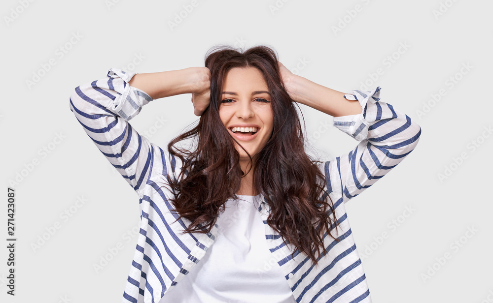 Indoor image of beautiful brunette young woman with long hair smiling cheerfully. Charming female smile broadly showing her white healthy teeth to camera while feeling happy and carefree. People Indoor image of beautiful brunette young woman with long hair smiling cheerfully. Charming female smile broadly showing her white healthy teeth to camera while feeling happy and carefree. People
