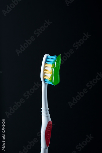 toothbrushes in black background with paste