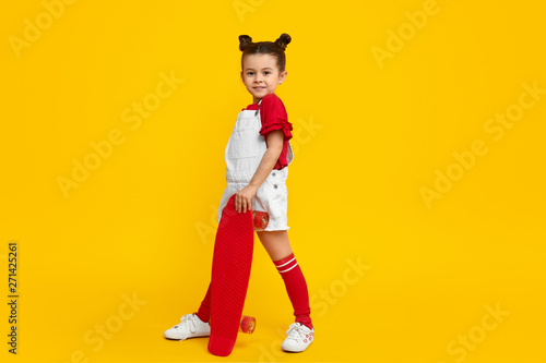 Trendy girl with red skateboard