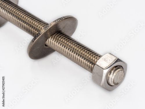 Inox nut on thread rod with wide washer on it shot on white.