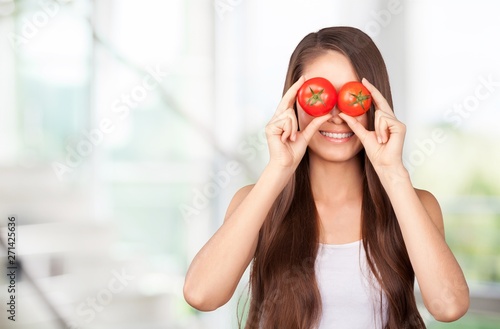 Young woman eating fruits from glass on blurred background