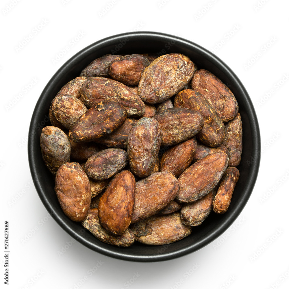 Roasted unpeeled cocoa beans in a black ceramic bowl isolated on white from above. Roasted unpeeled cocoa beans in a black ceramic bowl isolated on white from above.