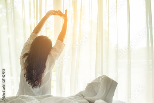 Asian women waking up stretching in bed at home, morning and sunny day.  Lifestyle Concept photo