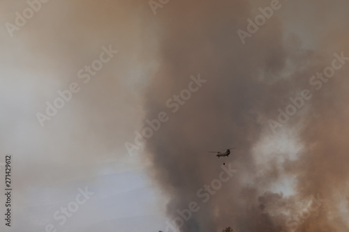 smoke on black background with helicopter fighting wildfires