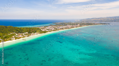 The coast of the island of Boracay. White beach and clear sea. Seascape with a beautiful coast in sunny weather. Residential neighborhoods and hotels on the island of Boracay  Philippines  view from