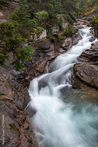  a beautiful waterfall cuts through the rocks at Maligne Canyon  Jasper National Park  Canada  long exposure to create blurred motion to the water  nobody in the image