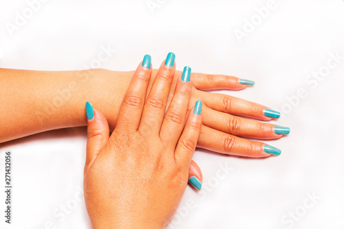 Beautiful closeup of hands of a young woman with long Blue manicure on nails.