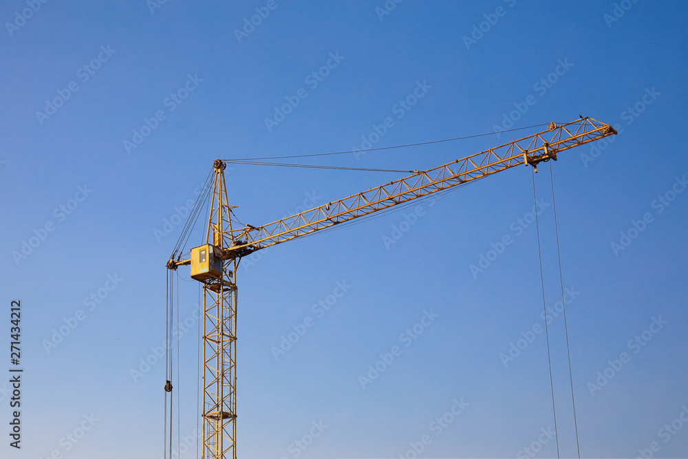 Industrial construction building crane against clear blue sky