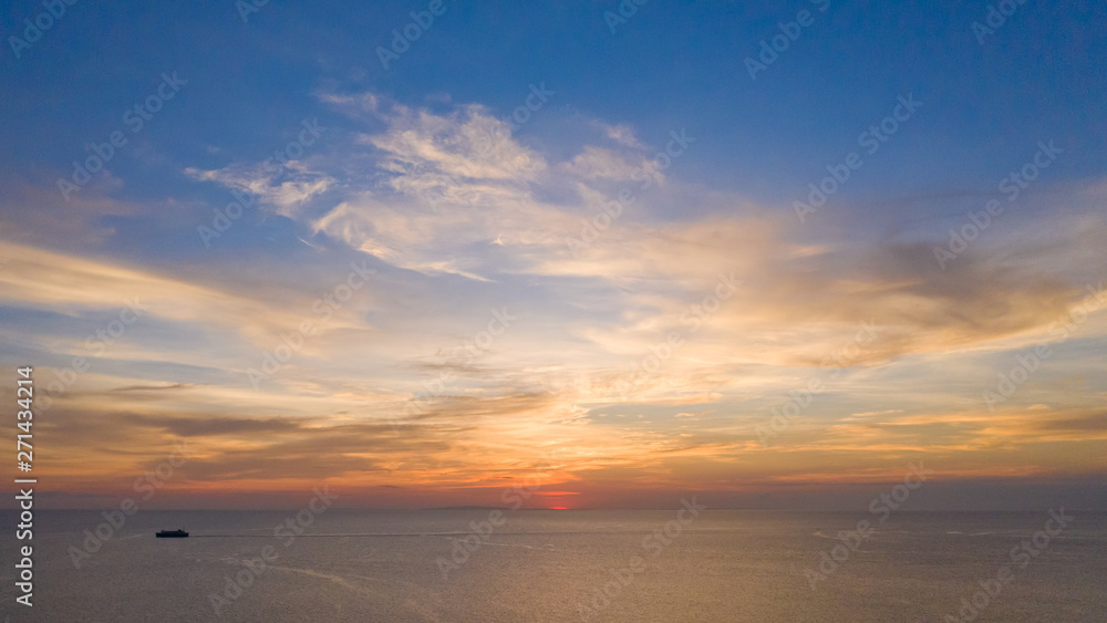 Aerial view of a Sunset sky background. Aerial Dramatic gold sunset with evening sky clouds over the sea. Stunning sky clouds in the sunset. Sky landscape. Aerial photography.