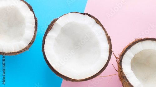 Three pieces of coconut on blue and pink background. Pieces of coconut on blue and pink.