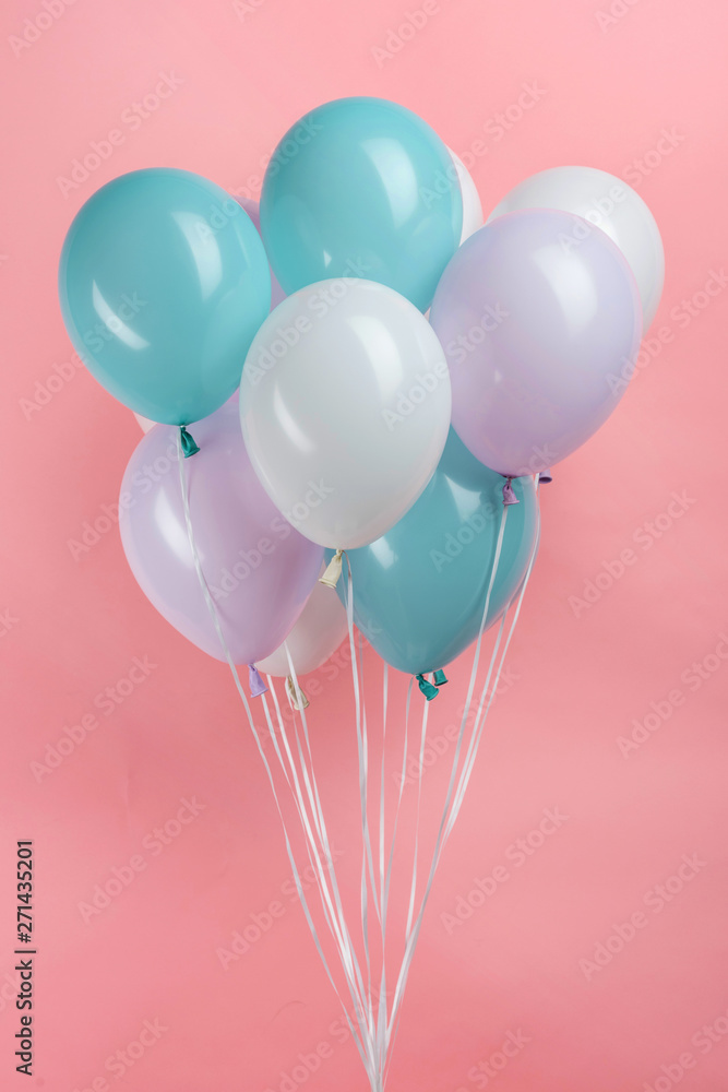 white, blue and purple party balloons on pink background