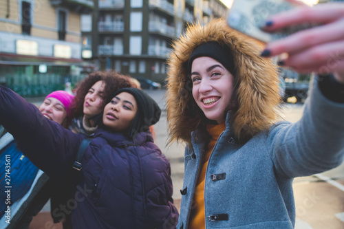 group of young multiracial women taking selfie with smartphone outdoor