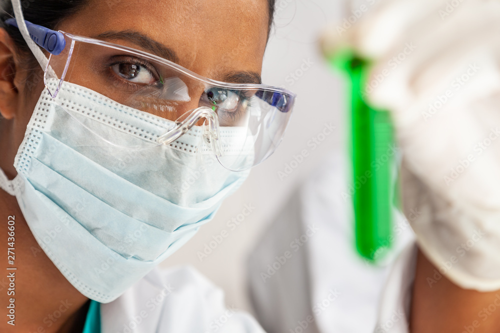 Asian Female Scientist Medical Research Lab with Test Tube of Green Solution Asian Female Scientist Medical Research Lab with Test Tube of Green Solution