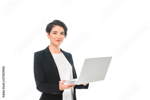 cheerful mixed race businesswoman holding laptop and smiling at camera isolated on white © LIGHTFIELD STUDIOS