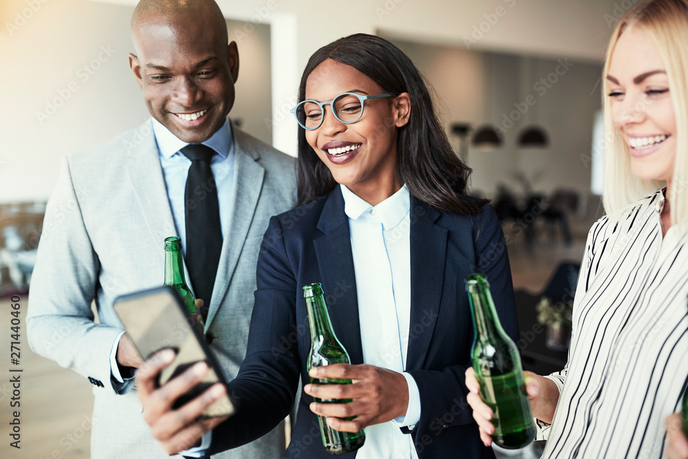 Smiling businesswoman showing coworkers photos over drinks after - obrazy, fototapety, plakaty 