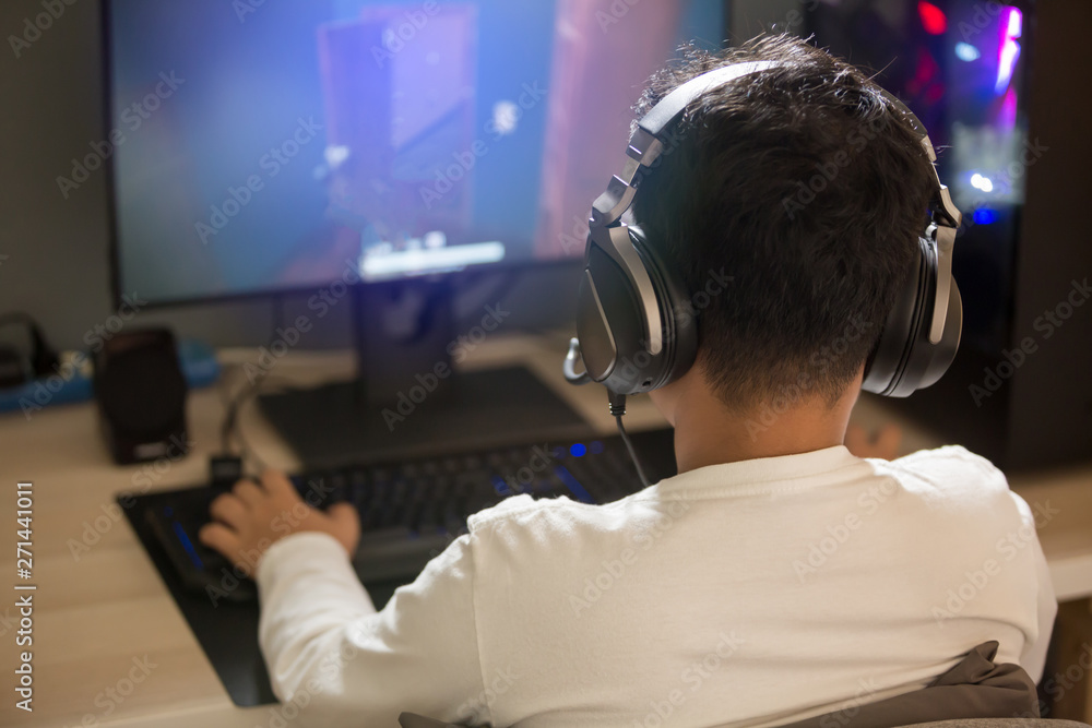 Portrait of asian boy gamer playing games on computer in the room at home. Portrait of asian boy gamer playing games on computer in the room at home.