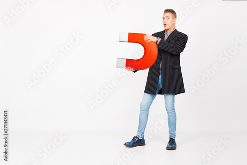 young man holding red horse shoe magnet attracting money and new customer, success business concept