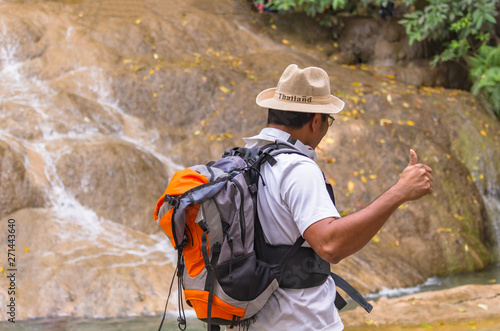 Asian tourists explore the forests and waterfalls in Thailand and feel confused with the route.