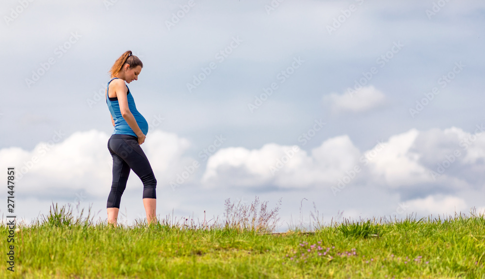 Pregnant woman walking in the park