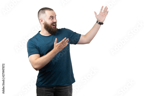 friendly young man pointing to his side and looking into the camera. isolated on white background