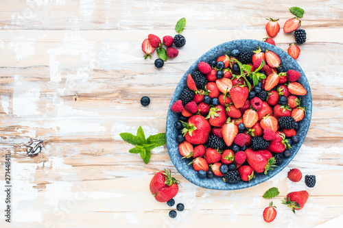 Draufsicht von frischen reifen Erdbeeren  von Blaubeeren und von Brombeeren auf Holztisch mit freiraumraum