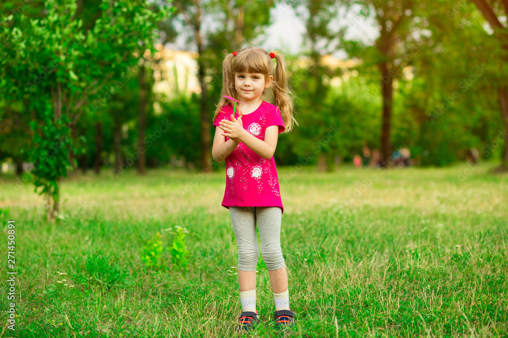 Cute female child catches soap bubbles in summer nature Cute female child catches soap bubbles in summer nature