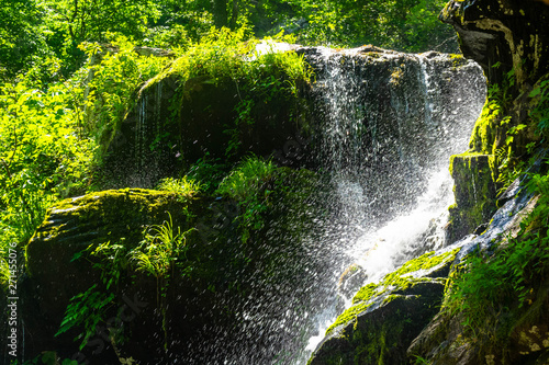 water spray from a waterfall as it launches itself off a cliff face photo