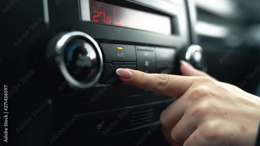 Female hand turns off air conditioning in car Female hand turns off air conditioning in car