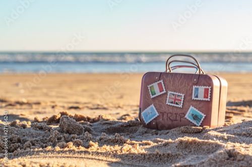 Travel suitcase on beach with copy space. Vacation concept