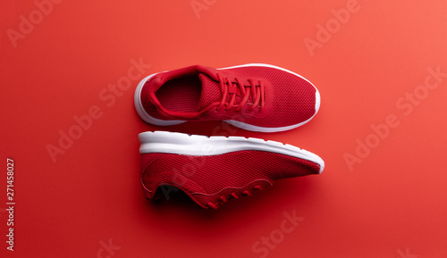 Fotografía A studio shot of pair of running shoes on red background