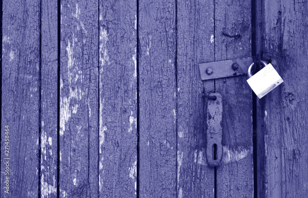 Old padlock on wooden gate in blue tone. Old padlock on wooden gate in blue tone.