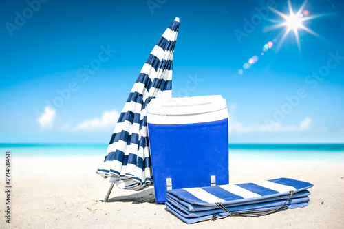 Summer time on beach and blue beach fridge on sand. Ocean landscape and sunny day. 