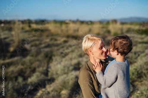 Portrait of young mother with small daughter in mediterranean nature.
