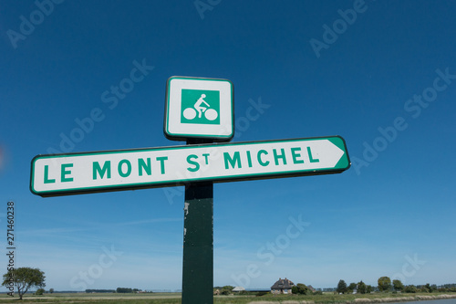 A sign shows the cycle route to tourist attraction Le Mont St Michel in France