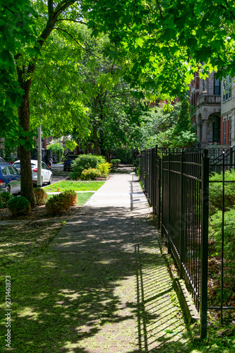 Sidewalk next to a Row of Old Fenced in Homes in Wicker Park Chicago	 photo