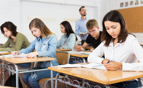 Girl writing test in classroom