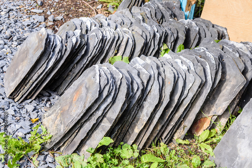 Pile of Bangor Blue slate roof tiles after they have been removed from a roof of abuilding being refurbished. photo