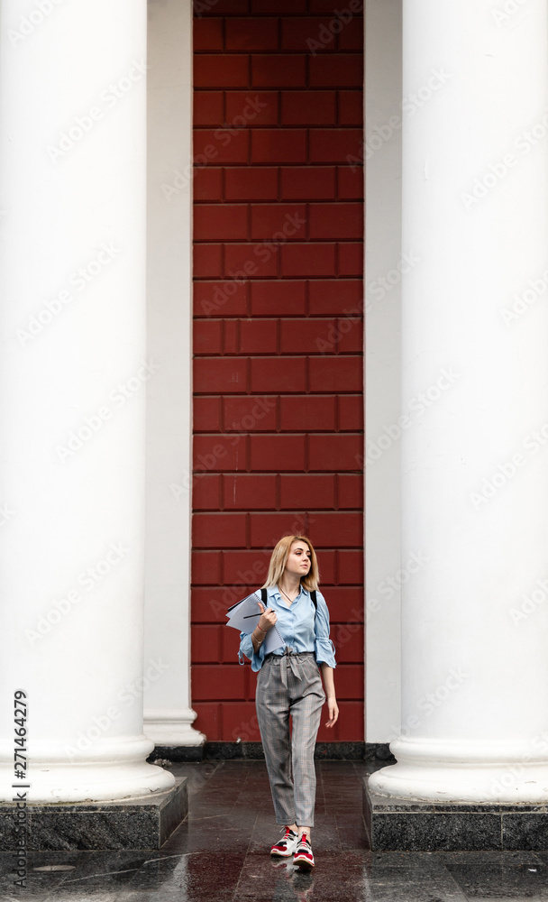 charming student goes to college. walk cute student with notebooks on campus. charming student goes to college. walk cute student with notebooks on campus.