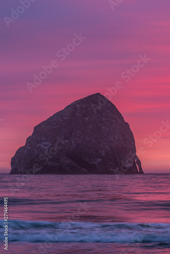 Haystack rock on the Oregon coast during vibrant pink sunset